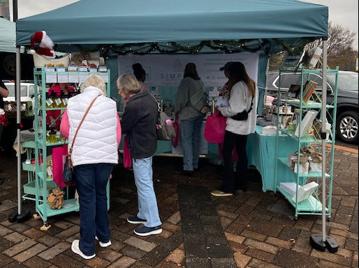 vendor event teal tent with customers shopping for soaps and naturla products 