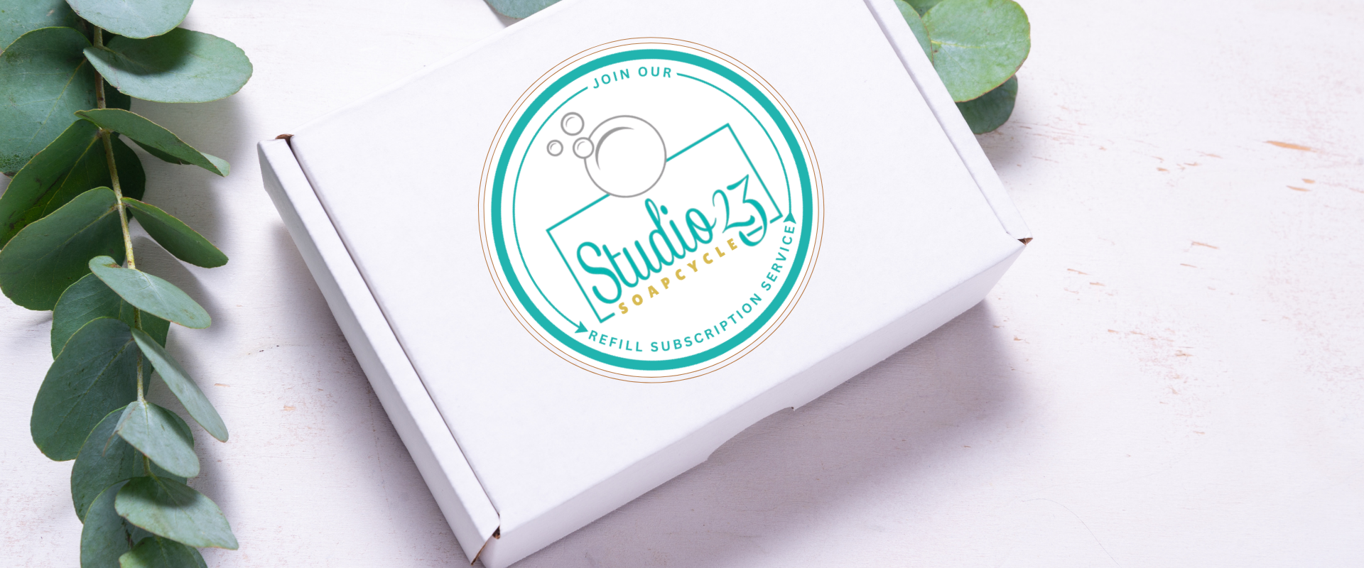 White box with 'Studio 23 Soapcyle' logo on a white background with green leaves