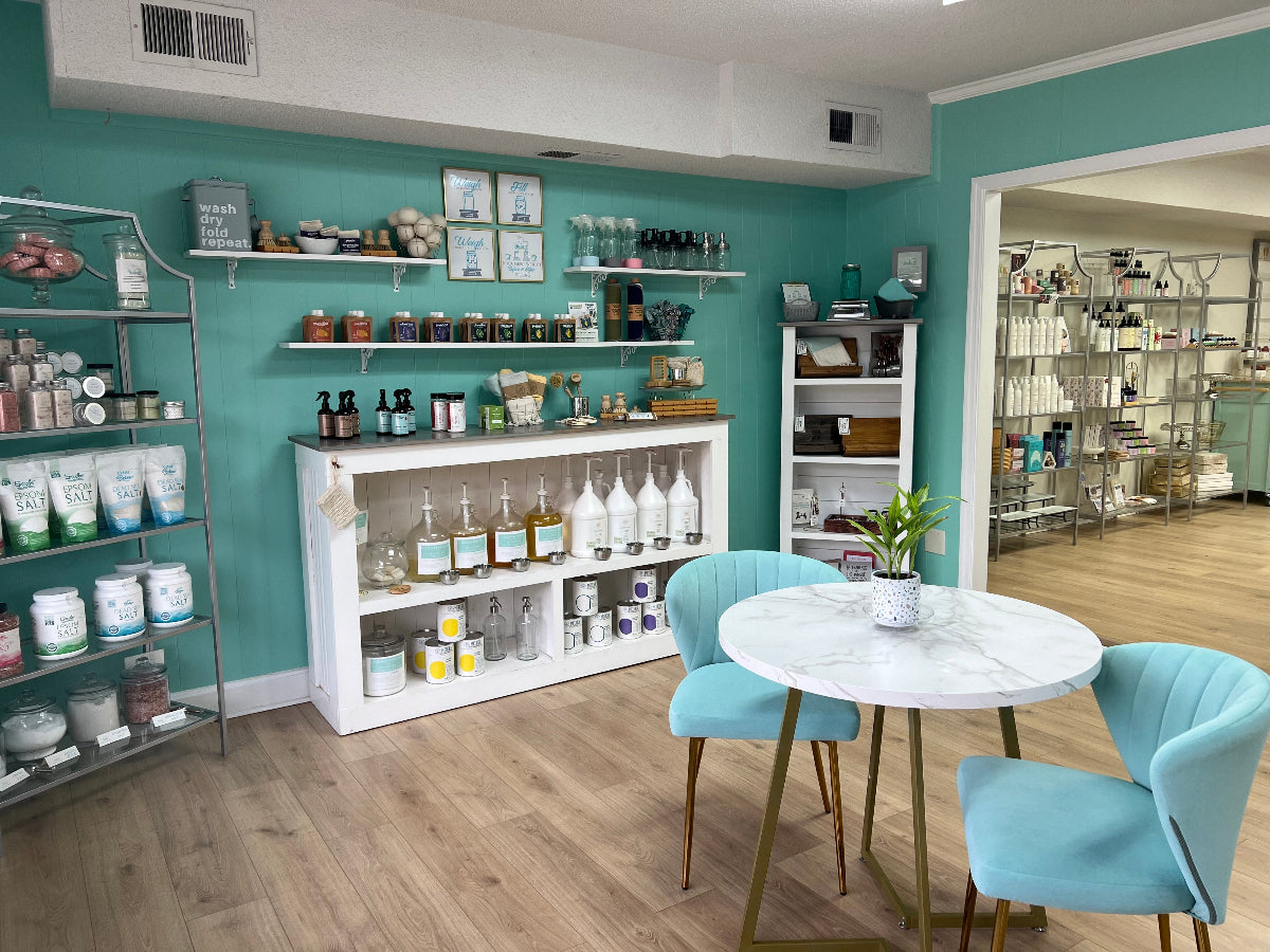 Studio 23 sustainability refill room with refill bar filled with gallon jars and pumps