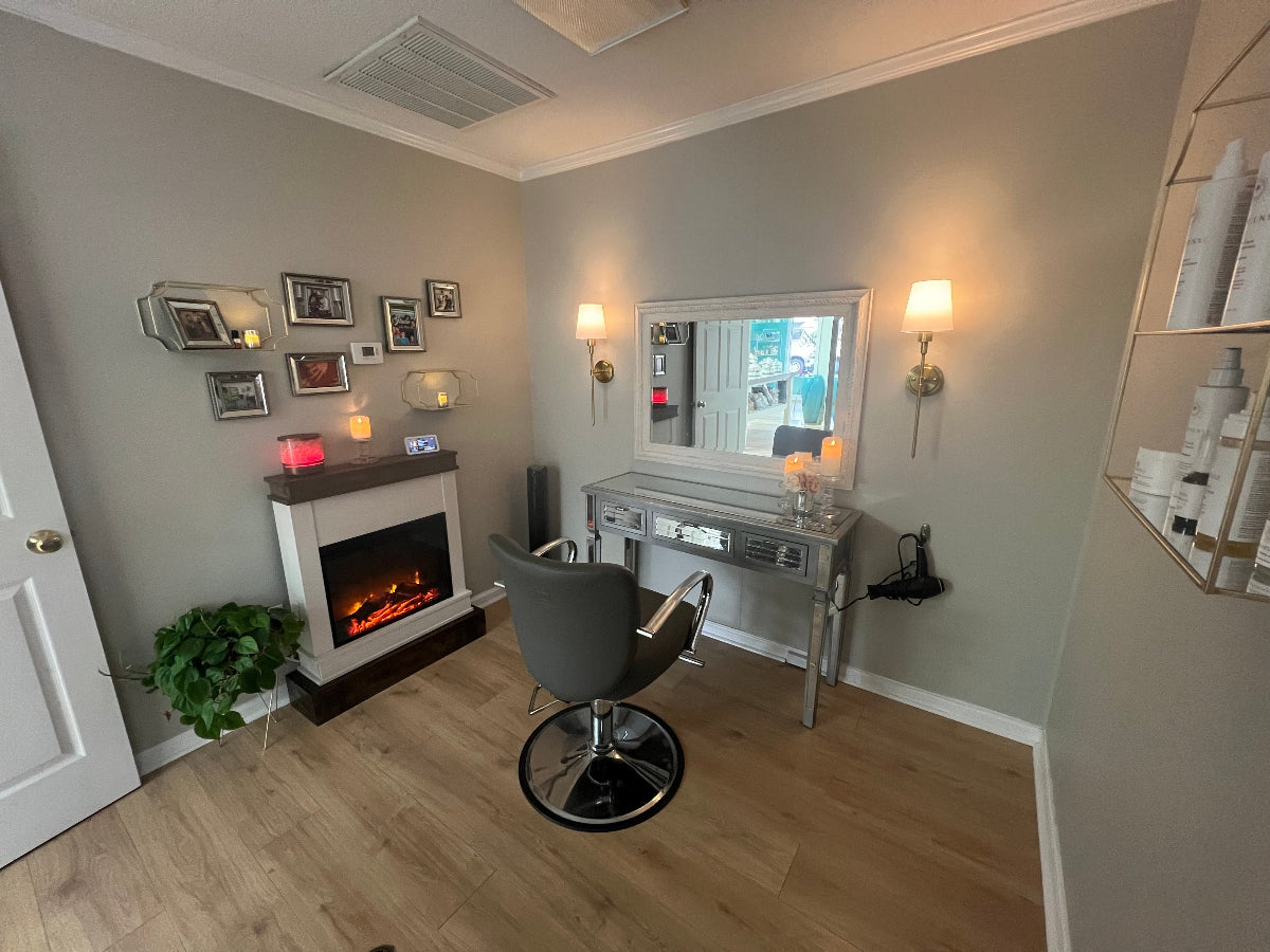 Studio 23 private treatment room with soft lighting and fireplace